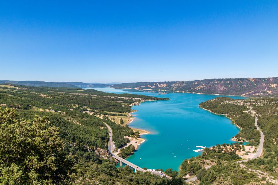 Une vue aérienne à couper le souffle d'un lac bleu éclatant au milieu d'une verdure luxuriante à Moustiers-Sainte-Marie, France.
