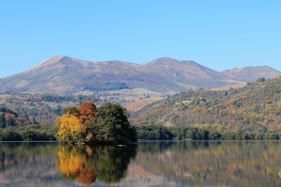 Un paysage d'automne serein capturant le lac Chambon avec des reflets et les montagnes du Puy-De-Dôme.