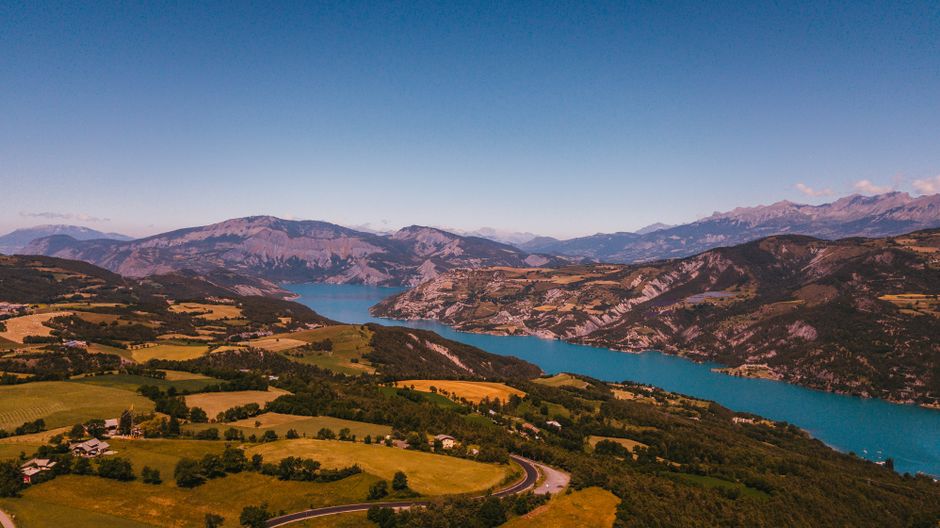 Superbe vue aérienne de la paisible campagne française, avec un lac pittoresque et les montagnes environnantes.