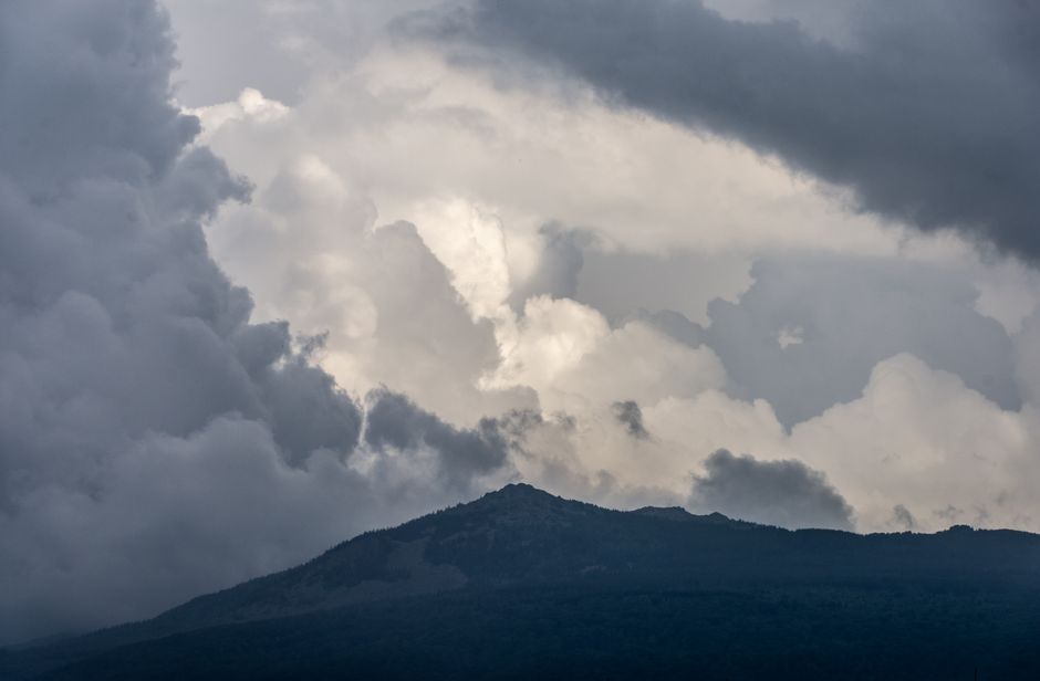 Vue captivante de nuages spectaculaires planant au-dessus d'un sommet montagneux, témoignant de la puissance de la nature.