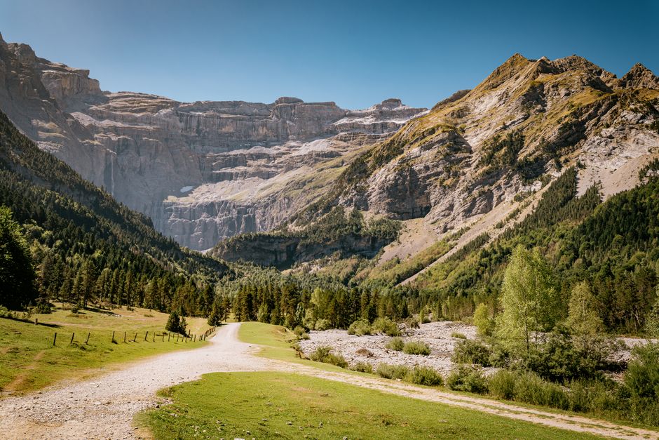 Paysage à couper le souffle du cirque de Gavarnie, avec ses montagnes escarpées et sa végétation luxuriante en Occitanie.